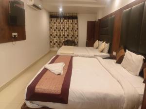 a hotel room with two beds and a flat screen tv at THE Flight path Unit By Urban Luxury Delhi Airport in New Delhi