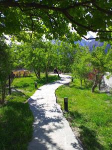 a path through a park with trees and grass at Grapes Garden Resort Hunza in Hunza