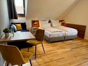 a bedroom with a bed and a table and chairs at JUNIPRO Hotel Schinderhannes in Weiskirchen