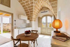 una cucina e una sala da pranzo con tavolo e lampada di Masseria Macchiaforte a Gallipoli