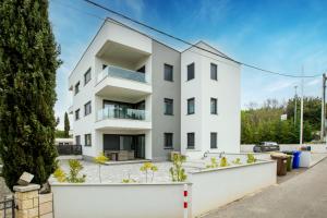 an apartment building with a white facade at Apartment Mužini Malinska in Malinska