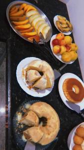 uma mesa coberta com pratos de diferentes tipos de alimentos em Topazzo Hotel em Uruara