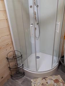 a shower with a glass door in a bathroom at Domki Letniskowe U Żuni in Chłopy