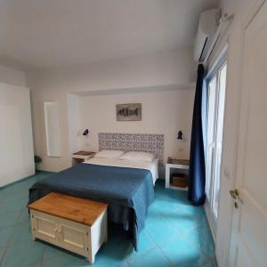 a small bedroom with a bed and a table at La Casa Di Massimiliano - Villa del Sole in Capri