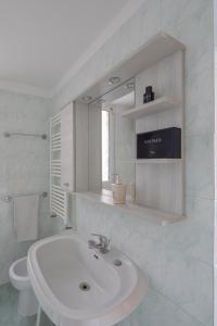 uma casa de banho branca com um lavatório e um espelho em EUR Mostacciano - 6 ospiti WIFi AC em Roma