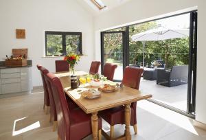 uma sala de jantar com uma mesa de madeira e cadeiras em Teign Vale em Cheriton Bishop