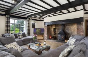 a living room with a couch and a fireplace at Broad Meadows Farmhouse 12 Guests in Bayton