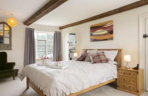 ein Schlafzimmer mit einem großen Bett und einem Fenster in der Unterkunft Broad Meadows Farmhouse 12 Guests in Bayton