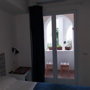 a bedroom with a bed and a window with a table at La Casa Di Massimiliano - Villa del Sole in Capri