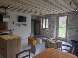 a living room with a table and chairs and a television at CHEZ FLORENT ET CELINE in Queige