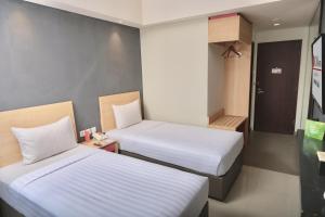 two beds in a small room with two beds sidx sidx sidx at @Hom Semarang Simpang Lima in Semarang