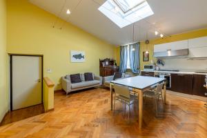 una cucina e un soggiorno con tavolo e sedie di Residenza Corsocangrande25 a Lazise