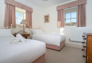 a bedroom with two beds and two windows at Bryn Mawr in Eglwys-Fâch
