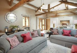a living room with two couches with pillows at The Cart Shed Shropshire in Downton