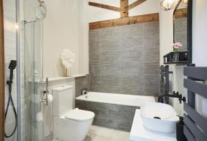 a bathroom with a toilet and a bath tub at The Cart Shed Shropshire in Downton