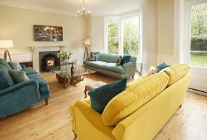 a living room with a yellow couch and a fireplace at Rosevean House in St. Agnes