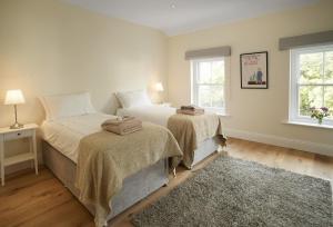 Un dormitorio con dos camas y dos ventanas. en Rosevean House, en St. Agnes