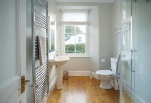 Un baño con inodoro, lavabo y ventana. en Rosevean House, en St. Agnes 30 fotos más