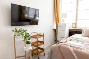 sypialnia z łóżkiem i telewizorem z płaskim ekranem na ścianie w obiekcie 2ndhomes Modern Studio with Central Location w Helsinkach