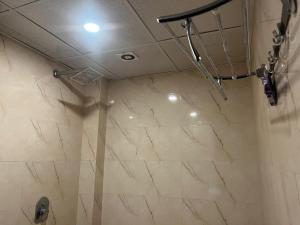 a shower in a bathroom with a marble tile floor at THE Flight path Unit By Urban Luxury Delhi Airport in New Delhi