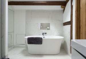 a white bathroom with a tub and a sink at The Timber Barn in Downton +21 photos