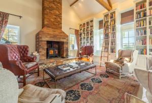 a living room with a fireplace and bookshelves at Bodney Lodge in Bodney