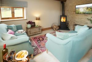 a living room with two blue chairs and a fireplace at The Stone Barn in Downton