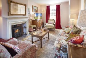 a living room with a couch and a fireplace at The Green in Coneysthorpe