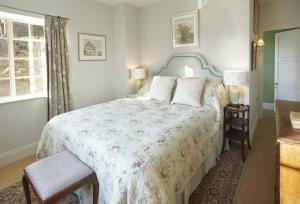 1 dormitorio con 1 cama con colcha de flores en The Green, en Coneysthorpe