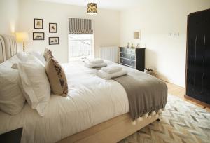 a bedroom with a large white bed with white pillows at Walesby House in Walesby