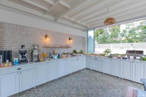 a kitchen with white cabinets and a large window at Bronze Hotel in Oludeniz