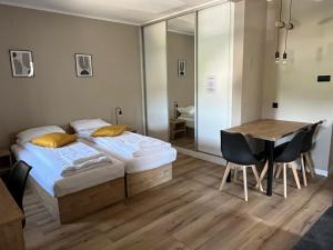 1 dormitorio con 1 cama y 1 mesa con sillas en Krollhouse Pokoje gościnne, en Wolbrom