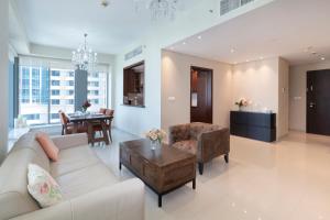een woonkamer met een bank en een tafel bij Downtown Dubai, Luxury 2 Bed 2 Bath Apartment - Pool, Gym, AirCon, Parking - Views of The Dubai Fountain & Burj Khalifa in Dubai