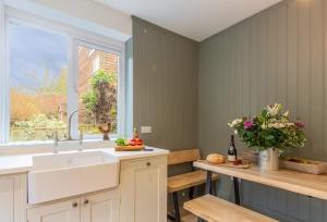 eine Küche mit Spüle und Fenster in der Unterkunft 1 Church Cottages in Westmeston
