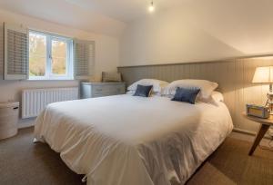 a bedroom with a large white bed with blue pillows at 1 Church Cottages 