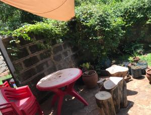 czerwony stołek siedzący na patio w obiekcie Private room in Townhouse, Kilimani. w mieście Nairobi