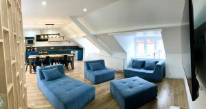 ein Wohnzimmer mit blauen Sofas und ein Esszimmer in der Unterkunft COC - La Maison Des Secrets in Calais