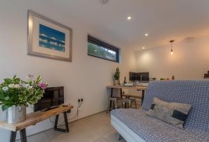 a living room with a couch and a table at 1 Church Cottages & Garden Room 