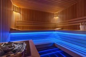 a bath tub with blue lights in a wooden room at My Story Gdynia Hotel in Gdynia