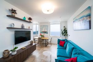 een woonkamer met een blauwe bank en een tv bij Luxury Apartment Libertas in Dubrovnik