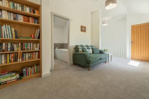 un soggiorno con divano e libreria con libri di Linden Barn a Orton