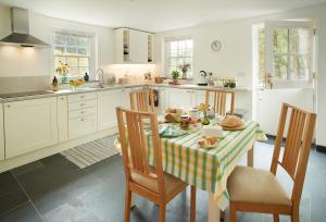 a kitchen with a table and chairs and a kitchen with white cabinets at Troedrhiwfawr in Aberystwyth