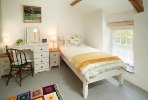 a bedroom with a bed and a chair and a dresser at Troedrhiwfawr in Aberystwyth