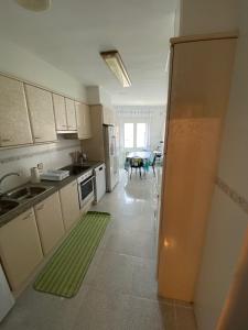 eine Küche mit einem Waschbecken und einem Tisch darin in der Unterkunft Appartement Spacieux proche commerces et plage Centre-Ville in Roses