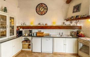 a kitchen with white cabinets and a clock on the wall at Nice Home In Escales With House A Panoramic View in Escales