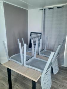 three chairs sitting on a table in a room at Charmant mobil-home 178 in Narbonne