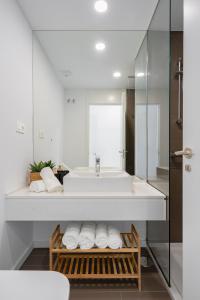 La salle de bains blanche est pourvue d'un lavabo et d'un miroir. dans l'établissement Oceana Views, Cancelada, à Estepona