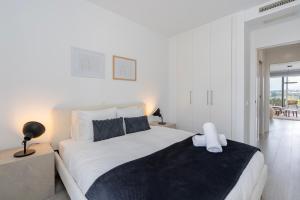 - une chambre blanche avec un grand lit et une fenêtre dans l'établissement Oceana Views, Cancelada, à Estepona