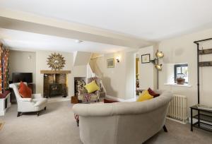 a living room with two couches and a fireplace at Rock Cottage in Minchinhampton