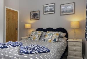 a bedroom with a bed with blue and white sheets at Rock Cottage in Minchinhampton